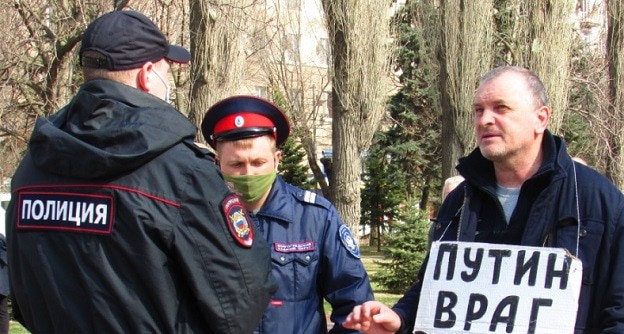 Владимир Тельпук с плакатом и полицейские.  Фото Вячеслава Ященко для "Кавказского узла".