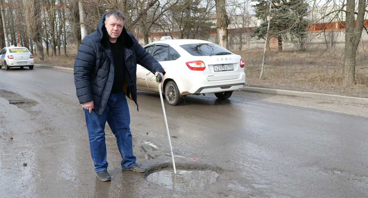 Роман Бабкин замеряет глубину ямы. Фото Сергея Снежина для "Кавказского узла".