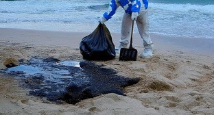 Волонтер убирает загрязненный песок. Иллюстрация создана "Кавказским узлом" с помощью ИИ в программе Photoshop